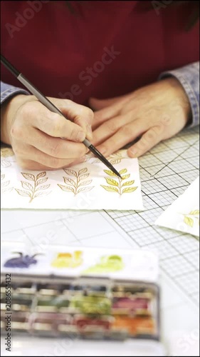 Woman hand painting watercolor leaves for scrapbooking