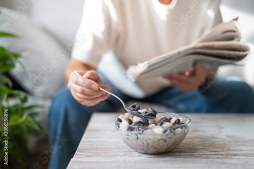 Foto Person enjoying a morning routine, slowly eating breakfast cereal with a spoon f