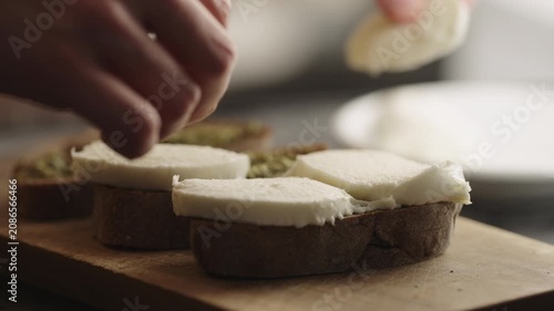 man spread pesto sauce on bread to make sandwich