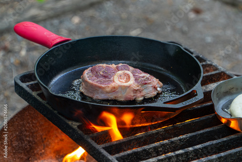 Cooking Steak over Campfire in Cast Iron Skillet