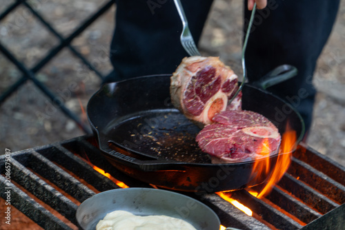 Cooking Steak over Campfire in Cast Iron Skillet