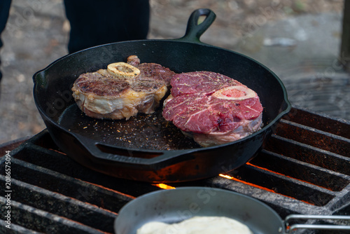 Cooking Steak over Campfire in Cast Iron Skillet