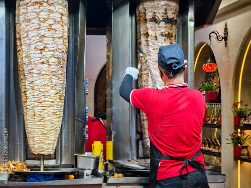 Canvas Print Kuala Lumpur, Malaysia - March 8, 2026: Chef preparing shawarma meat on vertical rotisserie inside Damascus Middle Eastern restaurant