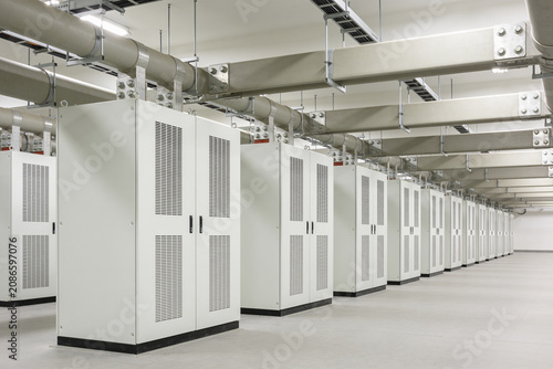Tableau sur toile Modern industrial server room with rows of white cabinets and overhead conduits