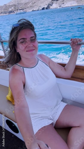 Vlogger woman sailing on boat trip in santorini, greece