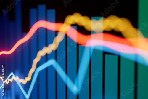 Stock market data visualization shows colorful lines and bars indicating trends in financial performance over time