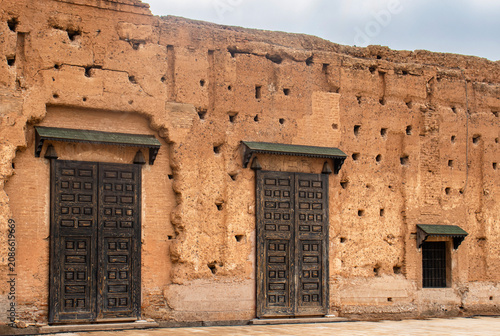 Historic Wooden Doors and Weathered Earthen Walls of a Medieval Royal Palace in Marrakech, Morocco