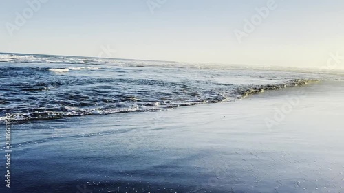 Serene Coastal Landscape Featuring Gentle Ocean Waves Washing Upon Sandy Shore
