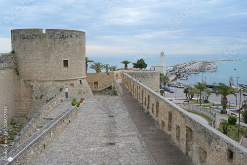 Foto Castello di Manfredonia overlooking busy harbor with lighthouse by the Adriatic Sea