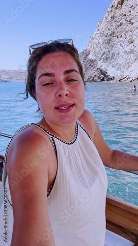 Female vlogger enjoying a boat trip in santorini, greece
