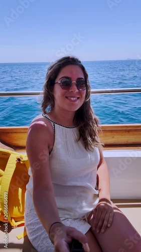 Young woman sailing on boat during santorini summer vacation