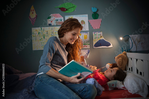 Mother reading a bedtime story for her little daughter