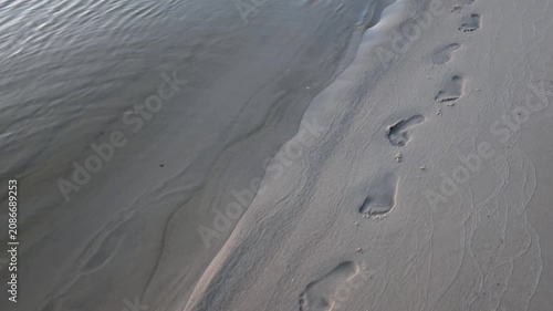 Barefoot Footprints on Sand Coastline Revealing Peaceful Ocean Sunset