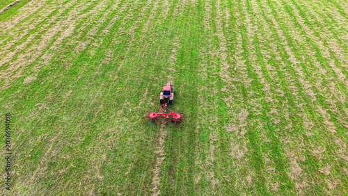 Tractor cultivating green field using a rotary tiller for soil preparation and farming tasks