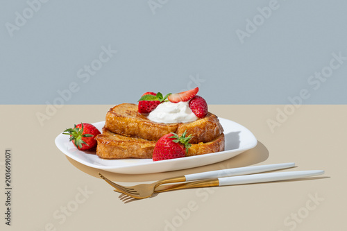 Brioche toasts with strawberry and whipped cream, drizzled with honey on a plate