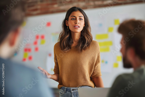Young Indian Female Professional Presenting Creative Ideas During Collaborative Team Meeting in Modern Office