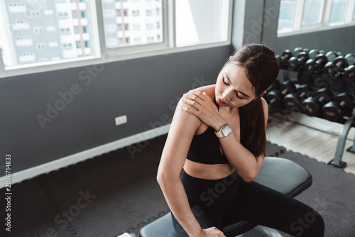 Foto Fitness woman suffering from shoulder pain after strength training in gym, showing muscle strain, sports injury, healthcare, rehabilitation, recovery and active wellness lifestyle concept
