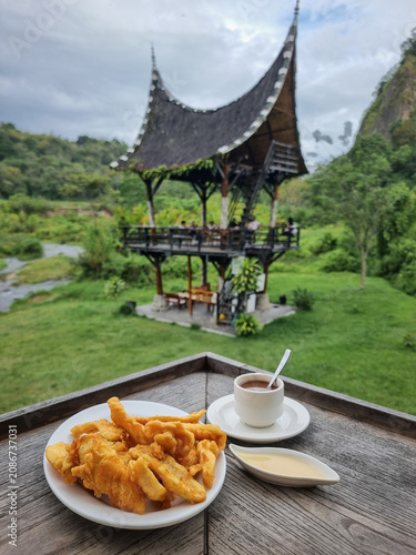 Bild auf Leinwand Indonesian style banana fritter and a cup of coffee served on the table at an ou