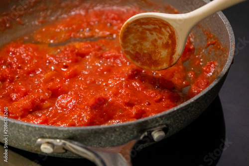 Close-up of fresh, flavorful tomato sauce simmering and bubbling gently in a rustic frying pan