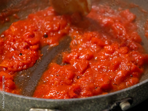 Close-up of fresh, flavorful tomato sauce simmering and bubbling gently in a rustic frying pan