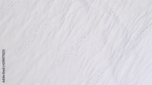 Soft white fabric background with crinkled texture waving