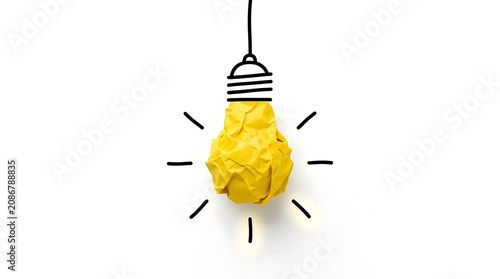 Crumpled paper light bulb with rays, symbolizing creative idea