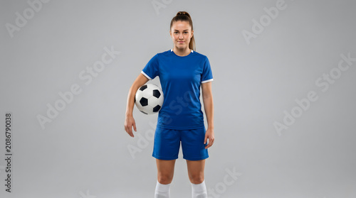 Athlete, Soccer. Portrait of young female soccer player with ball standing on isolated Background