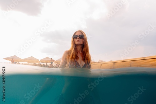Woman relaxing in summer vacation infinity pool