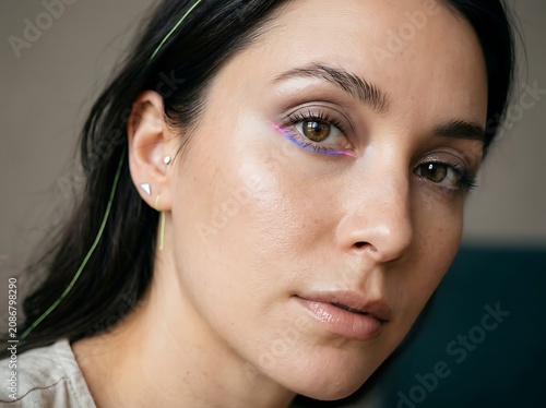 Close up portrait of a young woman with dark hair and green eyes.