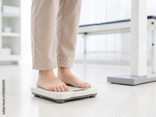 Patient's bare feet standing on a medical weight scale
