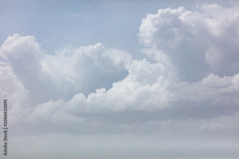 Obraz premium Soft white clouds drift against a pale blue sky