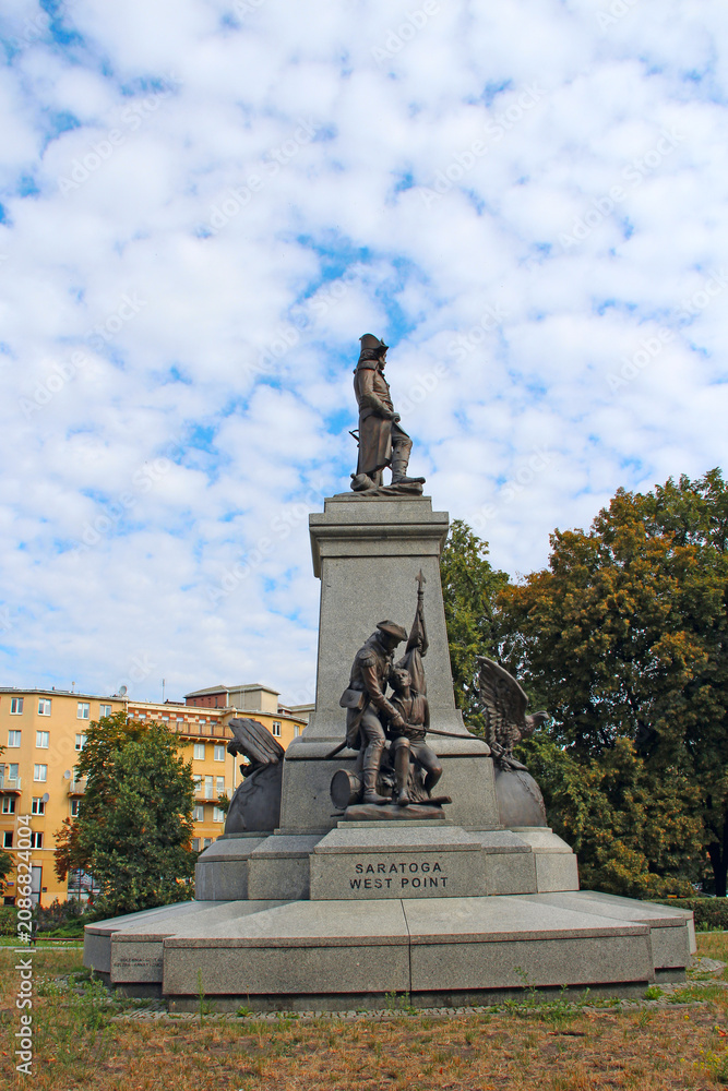 Fototapeta premium Tadeusz Kosciuszko monument in Warsaw with sculptures against cloudy sky.
