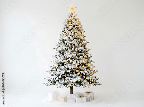 Snowy Christmas Tree Decorated With Warm Fairy Lights And Star Topper On A Simple White Background