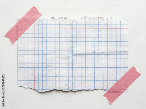 Torn Graph Paper Scrap Attached With Pink Adhesive Tape On A Clean White Textured Surface