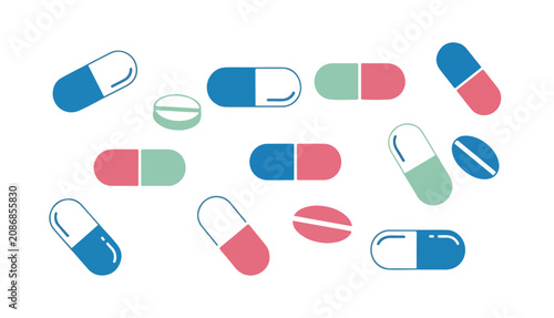 Medical pills and capsules in pastel colors scattered over a white background