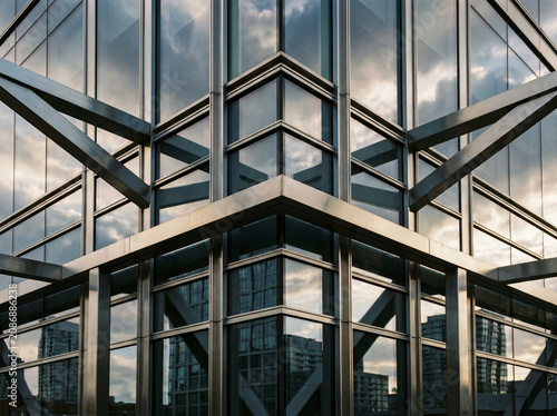 Modern office building facade with glass windows and steel beams showing architectural geometric patterns