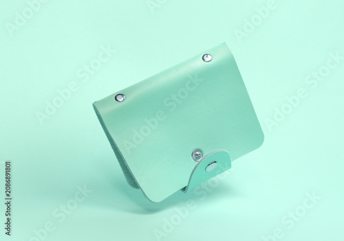Blue leather business card holder floating on a blue background