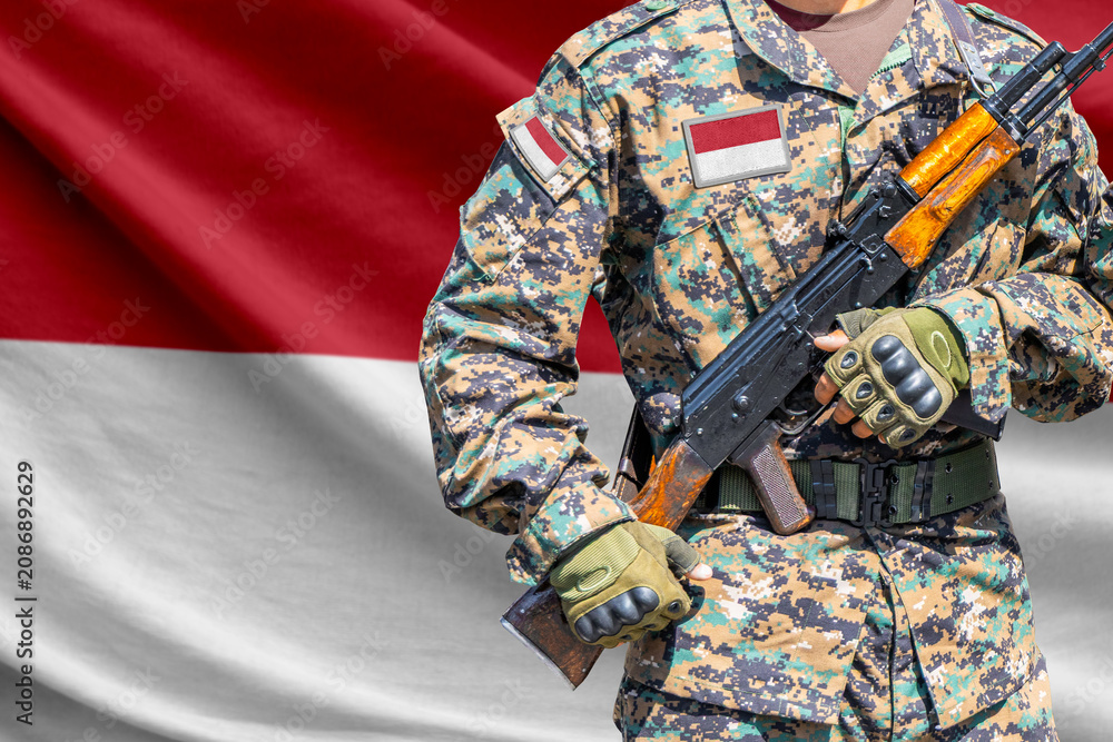 Fototapeta premium Indonesia flag with soldier holding assault rifle