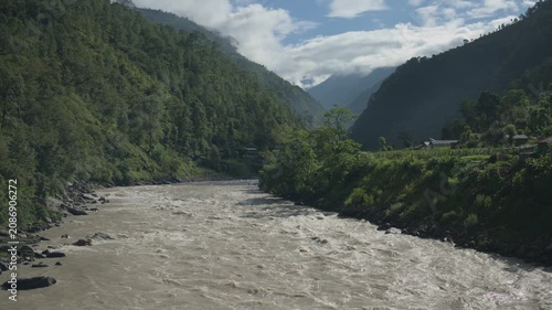 High Angle Profile of Concrete Suspension Bridge Structure Over Powerful River Rapids