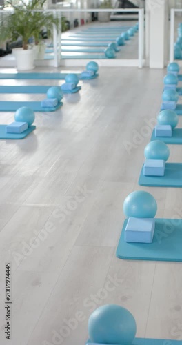 Vertical video: Camera is gliding forward, revealing teal mats and foam blocks in studio for class