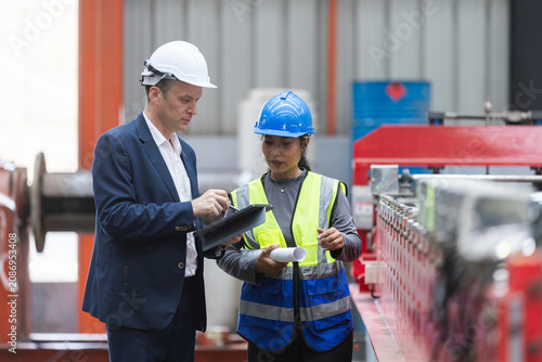Schilderij op canvas Manager and female worker engineer holding tablet during serious discussion abou