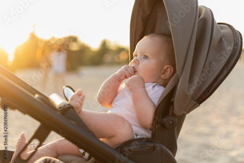 Baby in stroller at the beach during golden hour sunset