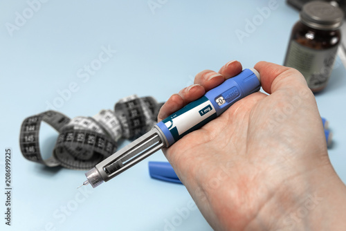 Quadro su tela Hand holding Ozempic injection pen for diabetes treatment.