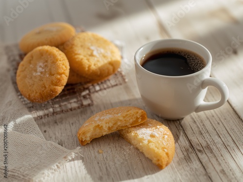 Freshly Baked Cookies with Black Coffee in White Mug on Light Wooden Surface