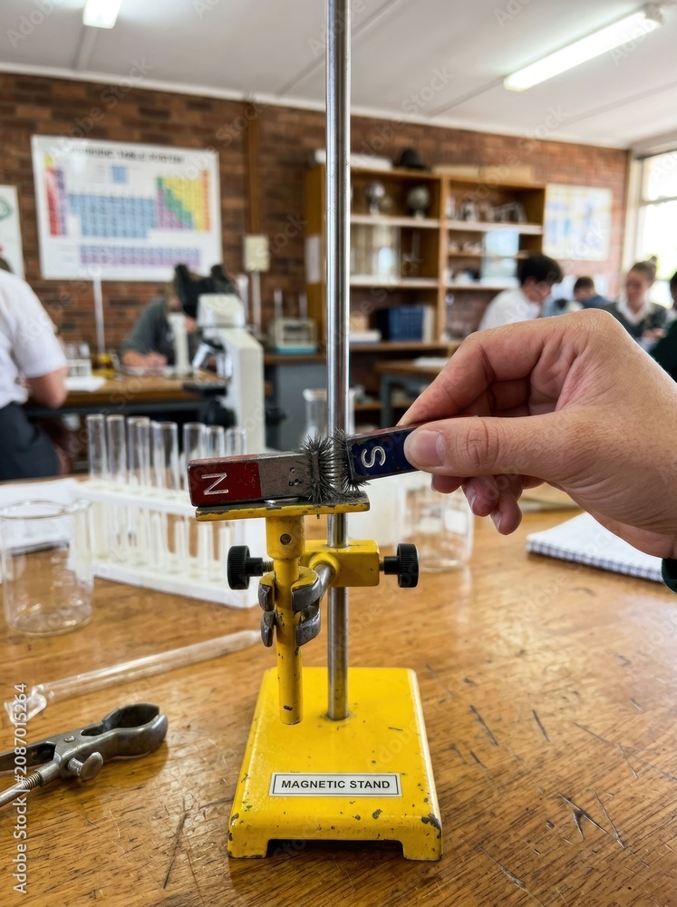 Fototapeta premium Student conducting a science experiment with a magnet in a classroom.