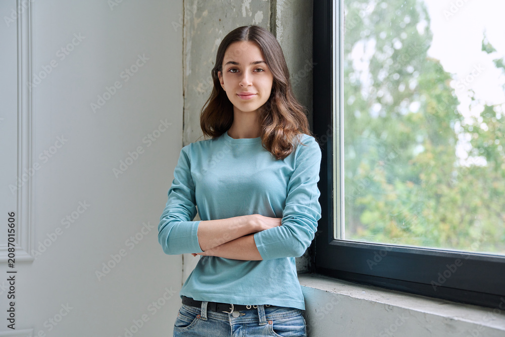 Obraz premium Calm teen girl with crossed arms looking at camera
