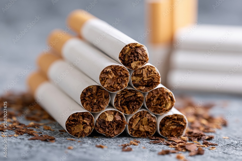 Naklejka premium The Cigarettes Pyramid Closeup of Cigarettes and Loose Tobacco Spills