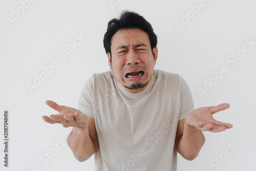Quadro su tela Crying Asian man expressing deep frustration and helplessness with open hands on white background