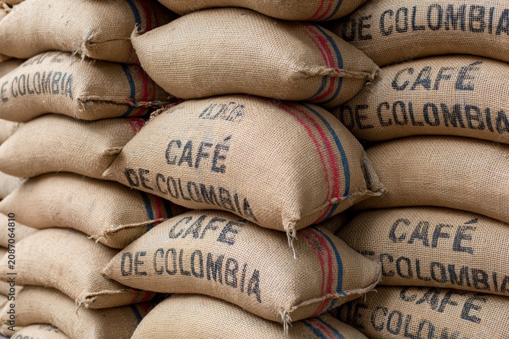 Naklejka premium The Burlap Coffee Sacks Stacked High in a Rustic Colombian Warehouse