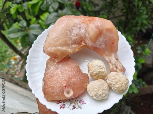 ​High protein raw food ingredients with chicken leg, fish steak, and meatballs on a plate
